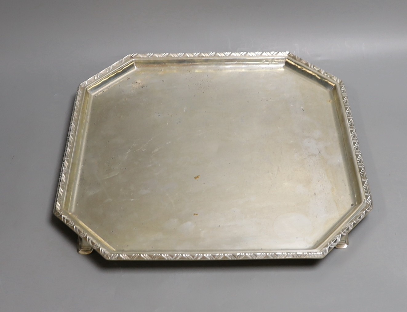 A George V silver octagonal salver, on swept feet, with engraved border, Goldsmiths & Silversmiths Co Ltd, London, 1935, 34.7cm